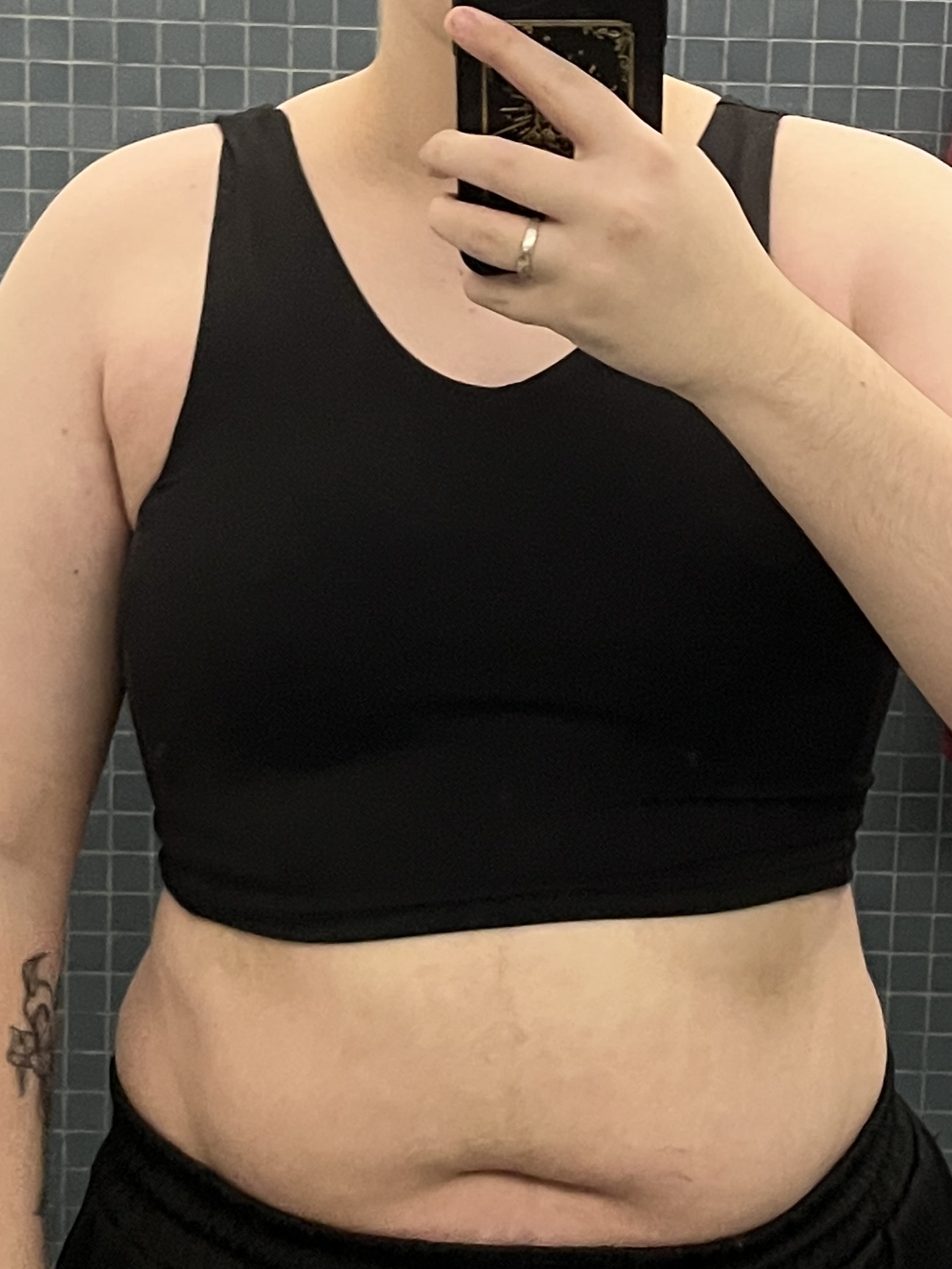 Trans man wearing a black half binder.